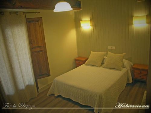 1 dormitorio con cama blanca y ventana en Fonda Urquizu en Beceite