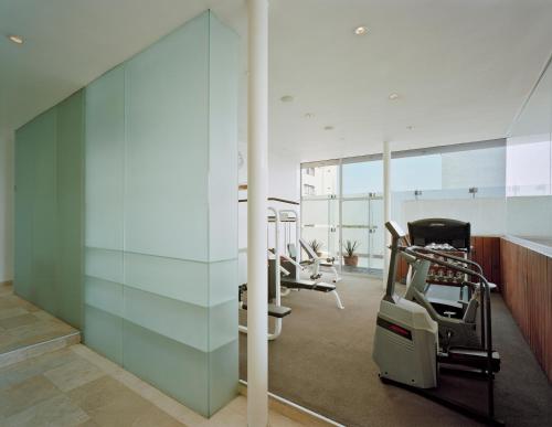 a row of exercise equipment in a gym with glass walls at Habita, Mexico City, a Member of Design Hotels in Mexico City