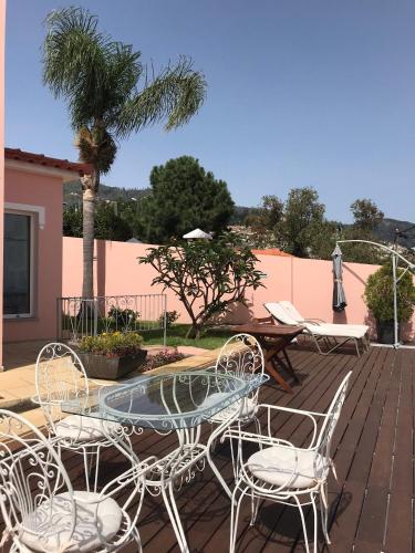 a patio with a table and chairs on a deck at Casa do Poço Funchal in Funchal