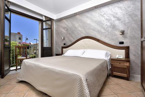 a bedroom with a bed and a large window at Hotel Nicoletta in Santa Maria Navarrese