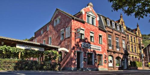 um velho edifício de tijolos vermelhos no lado de uma rua em Villa Croatia & Restaurant Adria em Klingenberg am Main
