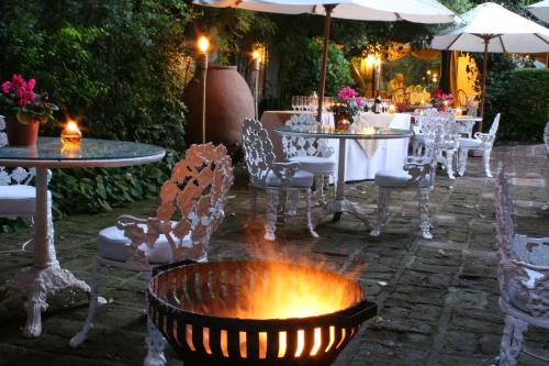 a patio with tables and chairs and a fire pit at Hotel Acacias de Vitacura in Santiago