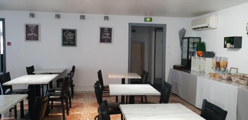 a dining room with tables and chairs and a counter at Hôtel Althea - Piscine et Sauna in Béziers