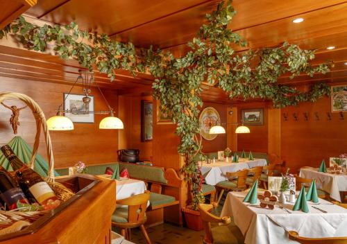 a restaurant with tables and chairs and plants at Landgasthof Adler in Hinterhornbach