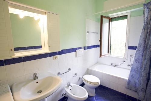 a bathroom with a sink and a toilet and a tub at Appartamento Il Prado - Goelba in Portoferraio
