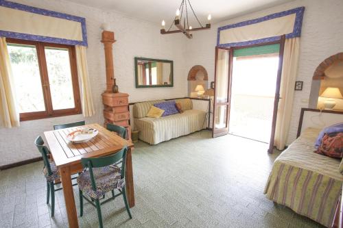 a bedroom with a bed and a table and a couch at Appartamento Il Prado - Goelba in Portoferraio