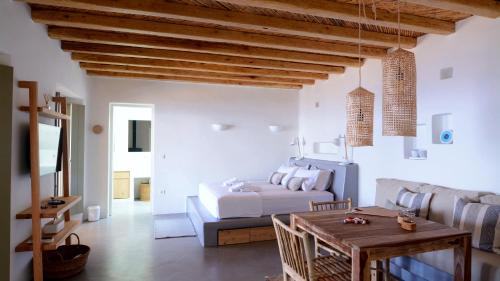 Dormitorio blanco con cama y mesa en Pénde Natura Residences, en Rámos
