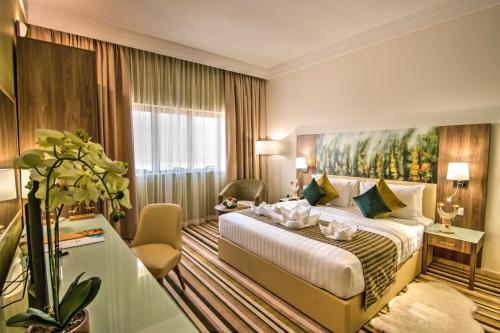 a hotel room with a bed with a painting on the wall at Royal View Hotel in Ras al Khaimah