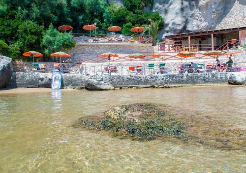 a beach with chairs and umbrellas in the water at Hotel Seggio in Vieste