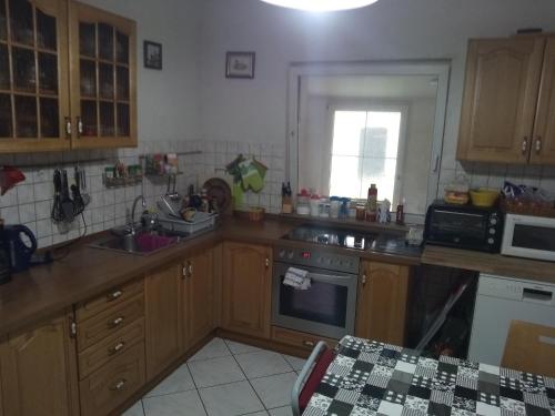 a kitchen with wooden cabinets and a counter top at Mein Marienhof in Bestensee