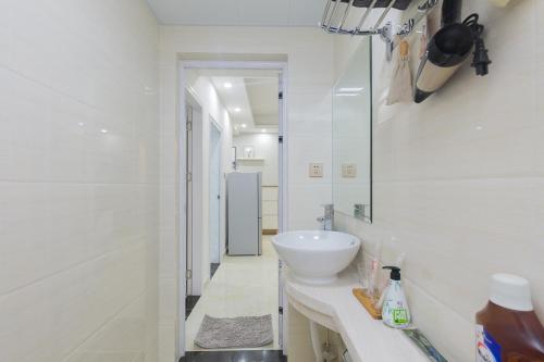 a white bathroom with a sink and a mirror at Haikou Meilan·Hainan Univeristy· Locals Apartment 00138360 in Haikou