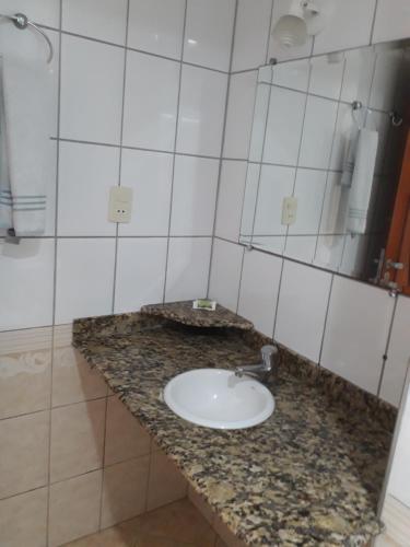y baño con lavabo y espejo. en Fragata Hotel en Guarapari