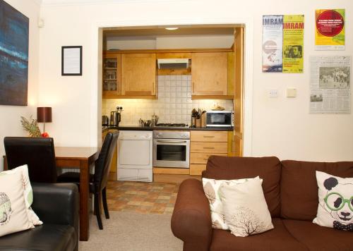 a kitchen and a living room with a couch and a table at Kieran's Place in Dublin