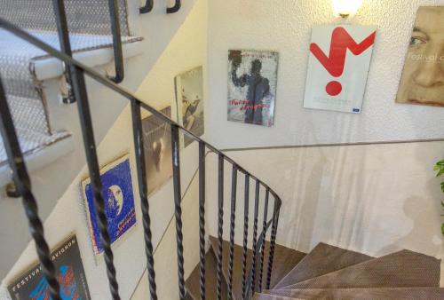 a staircase with posters and pictures on a wall at Hotel Mignon in Avignon