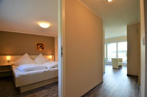 グラール・ミューリッツにあるFerienwohnungen Graal-Müritzのベッドルーム1室(白い枕付きのベッド1台付)