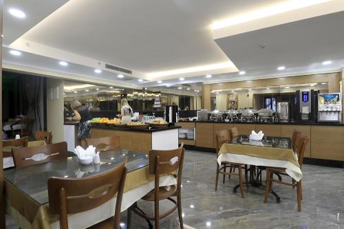イスタンブールにあるNL Amsterdam Hotelのテーブルと椅子、キッチン付きのレストラン