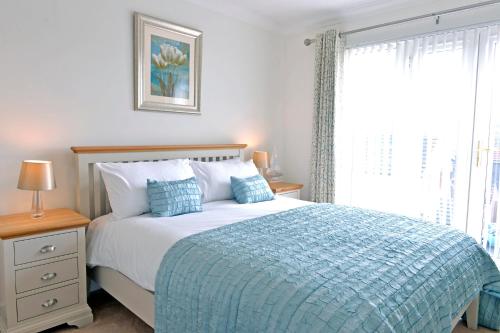 Pacific Heights في إيستبورن: غرفة نوم بسرير وبطانية زرقاء ونافذة