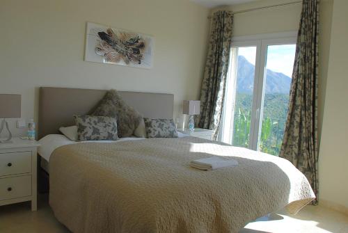 サン・ペドロ・アルカンタラにあるAmazing Panoramic Sea And Mountain View Townhouseのベッドルーム1室(ベッド1台、大きな窓付)