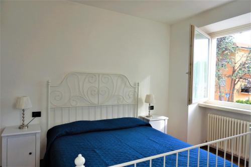 een slaapkamer met een blauw bed en een raam bij Apartment La Coccinella in Riva del Garda