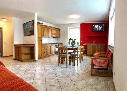 a kitchen with a table and a dining room at La Betulla Apartments in Commezzadura