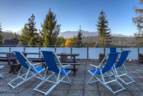 a patio with blue chairs and a table on a roof at Rysy in Bukowina Tatrzańska