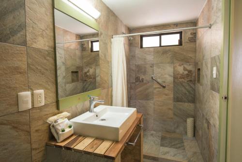 y baño con lavabo y ducha. en Hotel Palace Inn en Tuxtla Gutiérrez