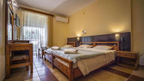 een slaapkamer met 2 bedden en handdoeken bij Thea Hotel in Possidi