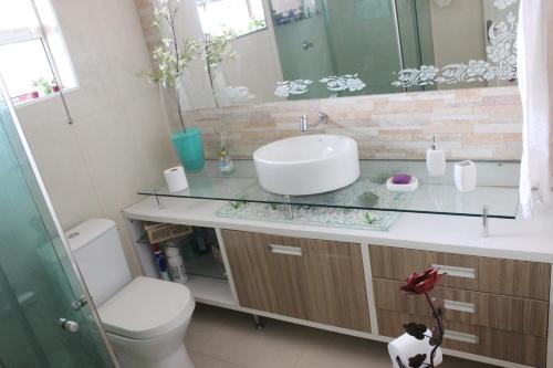 a bathroom with a sink and a toilet and a mirror at Aconchego da Helo in Mariana