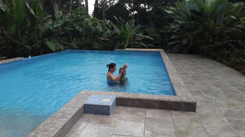 a woman is sitting in a swimming pool at Tropical Paradise Bungalows in Pital