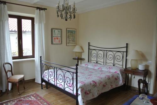 - une chambre avec un lit et un lustre dans l'établissement VILLA LE ROSE, à Cavour
