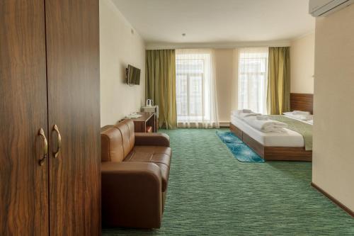 een hotelkamer met 2 bedden en een bank bij Almaz Hotel in Kazan