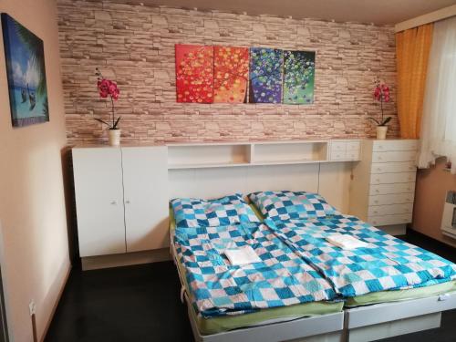 a bedroom with a bed and a brick wall at Appartement Schneerose in Tauplitz