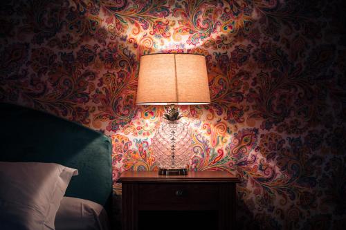 a lamp on a table next to a wall at Hôtel des Deux Clefs in Turckheim