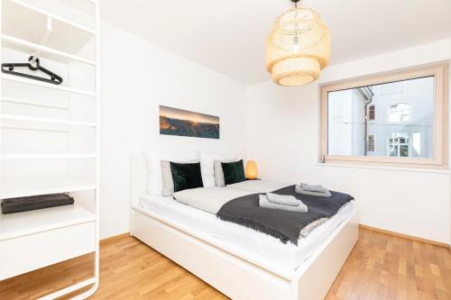 a white bedroom with a bed and a window at Top of Innsbruck in Innsbruck