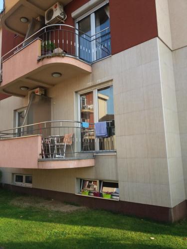 a building with a balcony with a table and chairs at BG apartman in Vrnjačka Banja