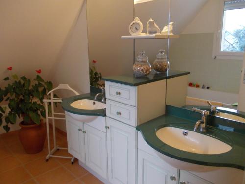 une salle de bain avec deux lavabos et un miroir dans l'établissement Chambre d'hôtes - La Maison de Jane, à Jullouville