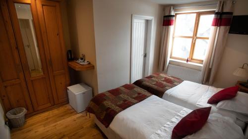 a hotel room with two beds and a window at The Pebley Inn in Chesterfield