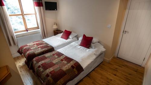 a bedroom with a bed with two red pillows at The Pebley Inn in Chesterfield