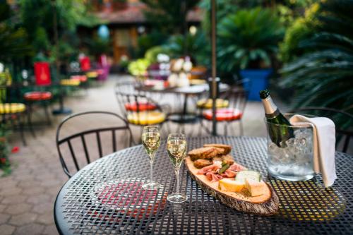 a table with a plate of food and wine glasses at Hôtel des Deux Clefs in Turckheim