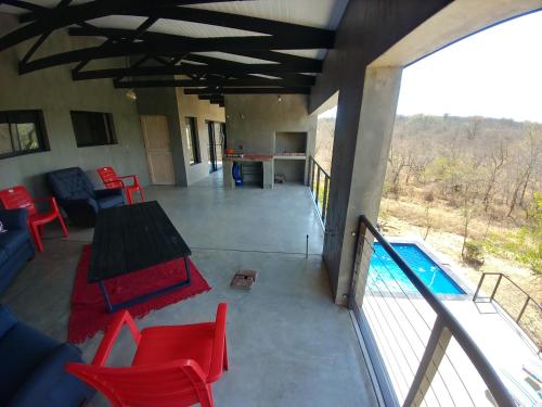 a patio with a table and chairs and a pool at Lionsview Private Lodge - 6 Lions in Marloth Park