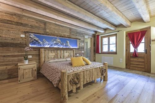 a bedroom with a bed and a tv on a wall at Agriturismo Alle Baite in Branzi