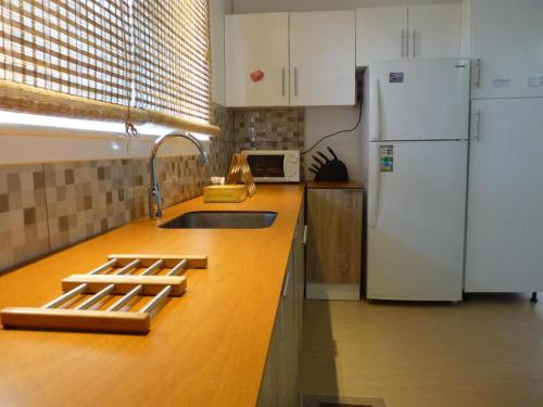 a kitchen with a sink and a refrigerator at AZORES GARDEN HOUSE - Suites B&B and Private Apartments - Self Access KEYBOARD in Ponta Delgada