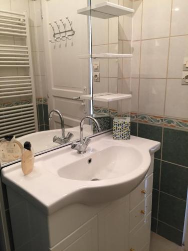 une salle de bain avec un lavabo et un miroir dans l'établissement Le Saint-Rémy, à Épernay