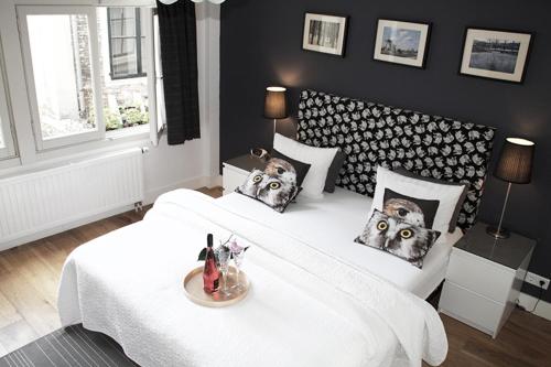 een slaapkamer met 2 bedden met uilen op de kussens bij Velvetamsterdam in Amsterdam