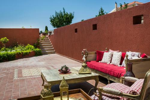 a patio with a red couch and a table at Palazzino Di Nionio in Karavadhos