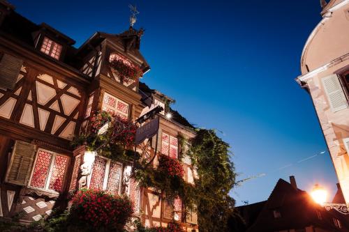 a building with flowers on the side of it at Hôtel des Deux Clefs in Turckheim