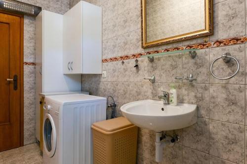 łazienka z umywalką i pralką w obiekcie Villa Steffany Apartments w mieście Kolan