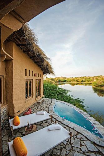 a resort with a swimming pool next to a building at Brij Lakshmansagar, Pali - Small Luxury Hotels of the World in Raipur
