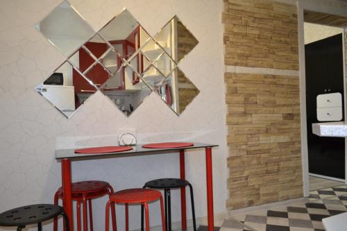 ペレスラヴリ・ザレスキーにあるКвартира в центре Переславля-Залесского.の壁に赤いスツールと鏡が備わるバー