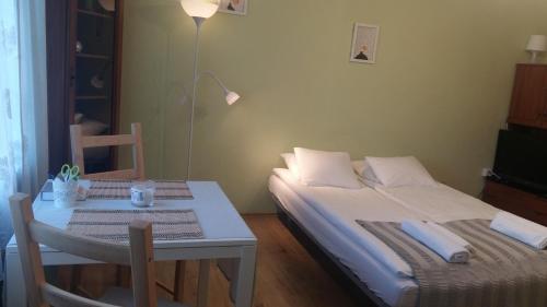 コジェニツェにあるApartament Kozieniceのベッドルーム(ベッド1台、テーブル、ランプ付)